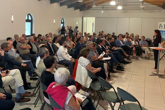 Christelle Morançais est debout avec un micro devant une salle comble de vendéens