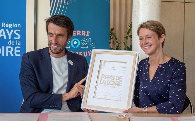 Tony Estanguet et Laurence Garnier tiennent un cadre avec le label "Terre de jeux 2024"