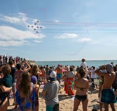 une foule estival sur la plage regarde dans le ciel 8 avions des ailes bleues